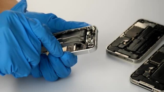 技术人员维修手机零件和恢复工具上的摄像头维修手机智能手机并升级移动技术。
