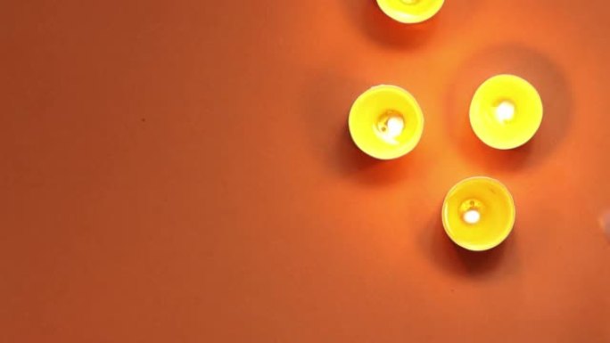 橙色背景上的茶蜡烛上的火光可移动图案，俯视图