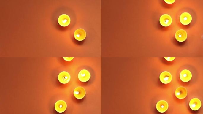橙色背景上的茶蜡烛上的火光可移动图案，俯视图