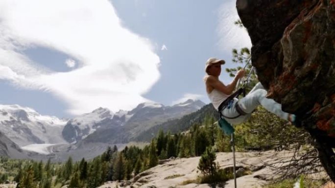 年轻女子在阿尔卑斯山降岩面。攀登冒险