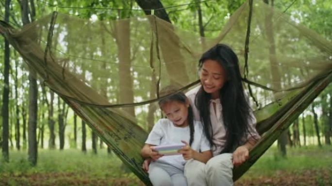 happy asian woman together with daughter watching 