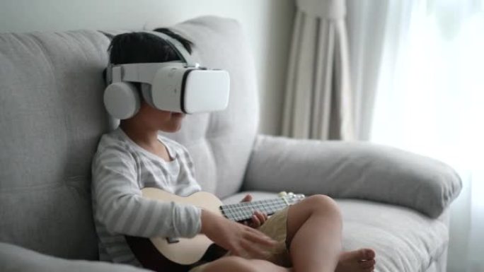 亚洲男孩在家用VR技术练习吉他和夏威夷四弦琴。自我学习和技术的概念
