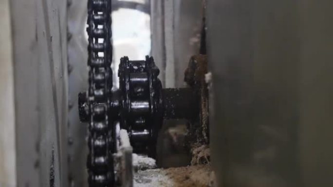 旧的齿轮轴旋转机构和用黑色油脂润滑的链条缓慢旋转。生产中旧机器的驱动机构在运行过程中被灰尘和面粉堵塞