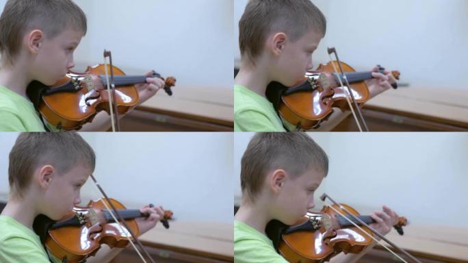 男孩在学校的音乐课上练习拉小提琴。