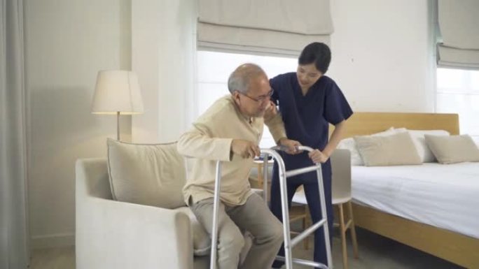 亚洲女护士，女儿帮助父亲从椅子上站起来，在家里的卧室或医疗保健中支持老年老年患者。人们的生活方式。家