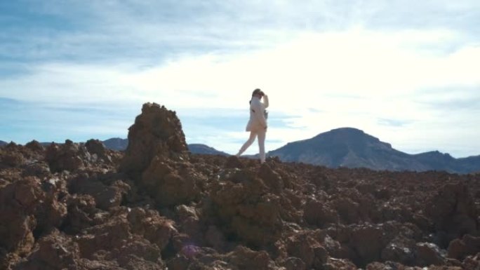 旅游妇女在特内里费岛的泰德火山国家公园中穿过凝固的熔岩山