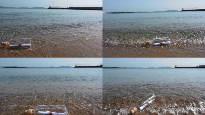 一个玻璃瓶的特写镜头，在沙滩上有一条信息。