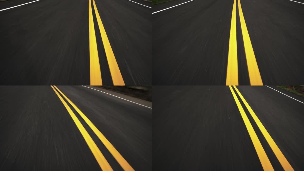 高速汽车在沥青路面上行驶的前pov视图与双黄线汇合