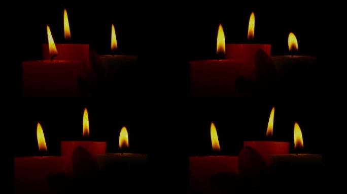 关闭蜡烛火焰在风中轻轻摇摆。在黑暗中旋转燃烧的蜡烛。