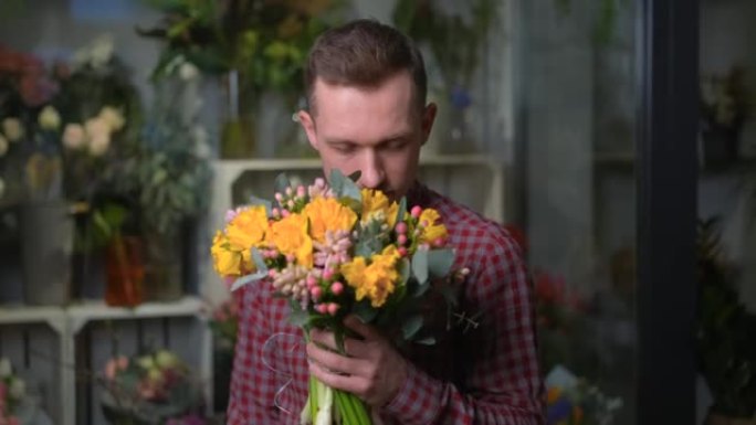 开朗浪漫的男人嗅着一束鲜花，4k