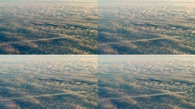 喷气式飞机飞过云层，留下凝结的空气轨迹。鸟瞰图