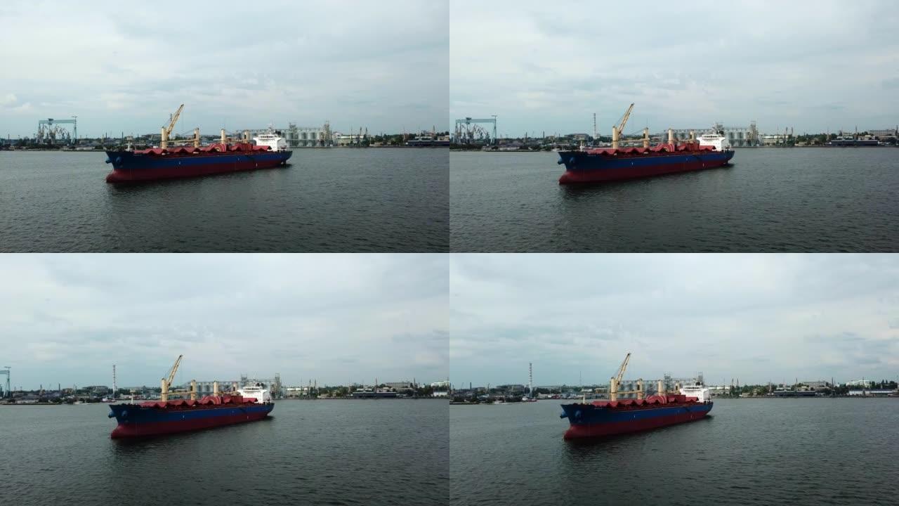 在平静的海面上漂浮着红色货运谷物船的鸟瞰图。以廉价方式运送大型货物的概念。