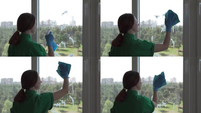清洁公司工人或家庭主妇使用洗涤剂和窗户清洁布清洁窗户。用喷雾瓶清洗窗户。