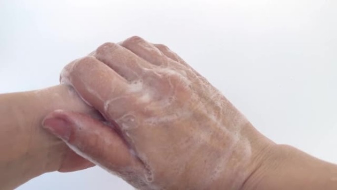 用肥皂清洗的女性手的特写镜头，隔离在白色背景上。