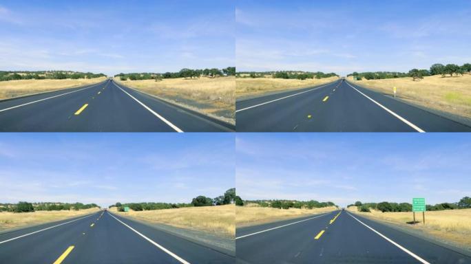 穿过汽车挡风玻璃的加利福尼亚高速公路的景色。在炎热的晴天在沙漠中的高速公路上行驶。汽车在挡风玻璃上的