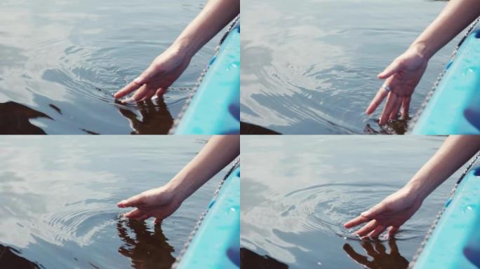 年轻女子的近手，在湖中阳光照射下触碰水和水反射。它展示了暑假与大自然放松和平静的概念。