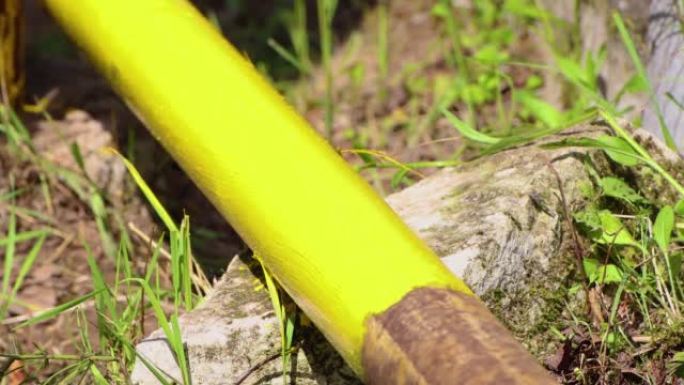 特写画笔用黄色油漆在管道上涂漆。