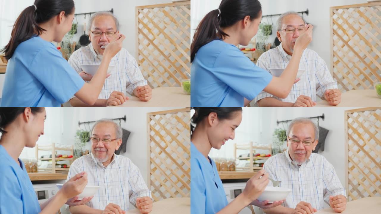 亚洲护理护士为坐在餐桌上的老人提供食物。有吸引力的年轻专业护理女医生支持和照顾养老院快乐的老年成熟祖