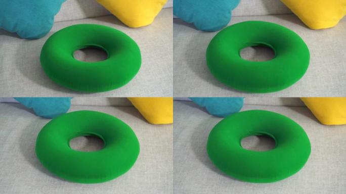 沙发上的圆形绿色矫形枕头特写，痔疮的概念