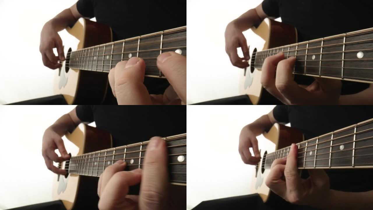 音乐家在白色背景上演奏原声吉他。男人的手指触摸吉他的琴弦，使它们振动并演奏歌曲的旋律。木制指板吉他和