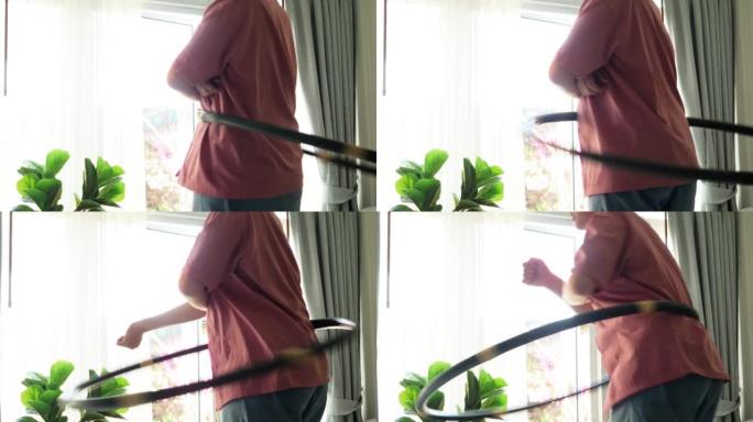 亚洲男孩在家里的窗户附近玩呼啦圈，积极的生活方式理念。