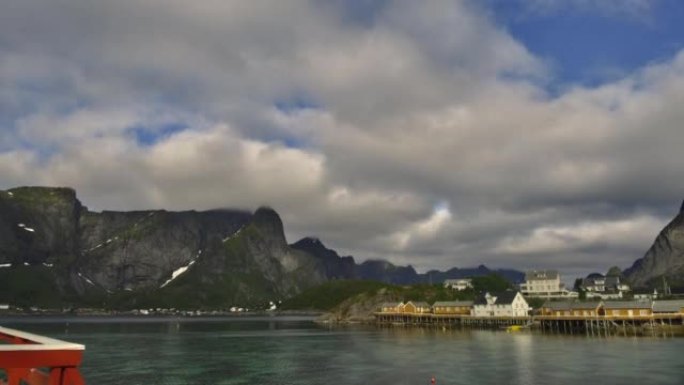 4k timelaspe在挪威夏季罗弗登群岛哈姆诺伊岛上的传统挪威渔夫小屋rorbuer上移动云层。