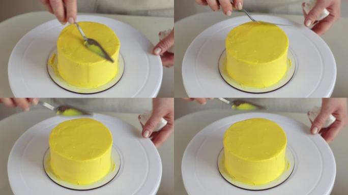 糖果用烹饪刮铲特写在蛋糕上放黄色奶油