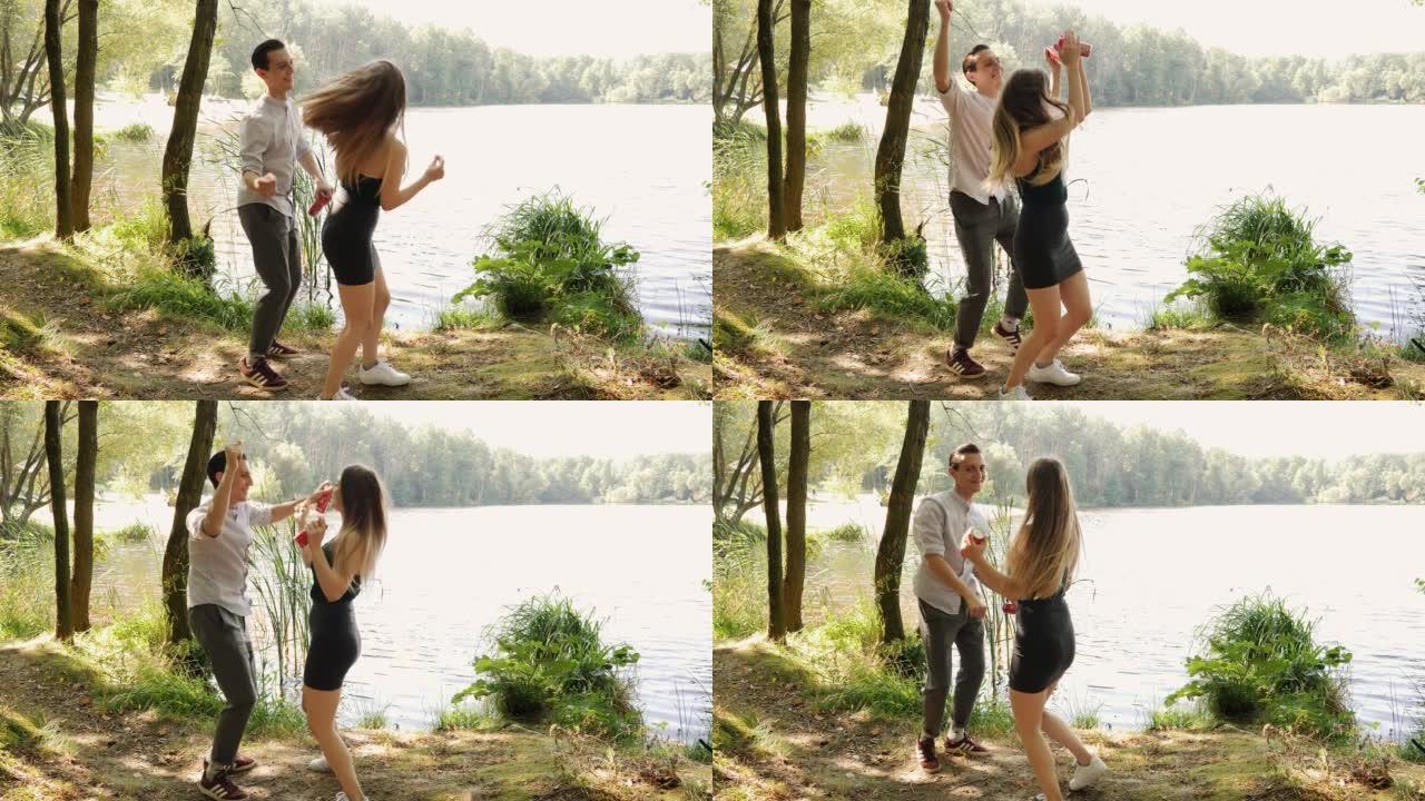 快乐的年轻人夫妇在湖岸乡村大自然中跳舞，约会时心情愉快