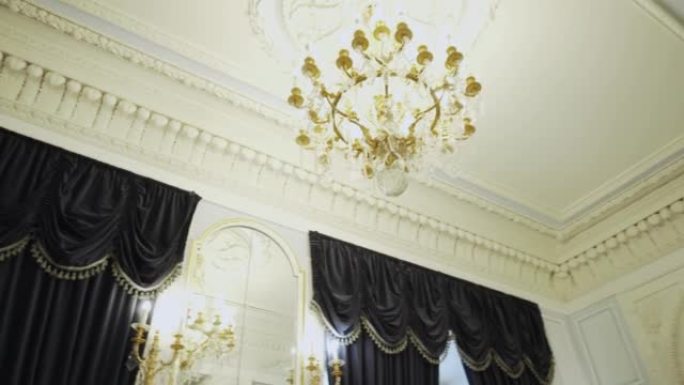 天花板上悬挂着水晶吊灯。天花板和柱子上的灰泥装饰条。