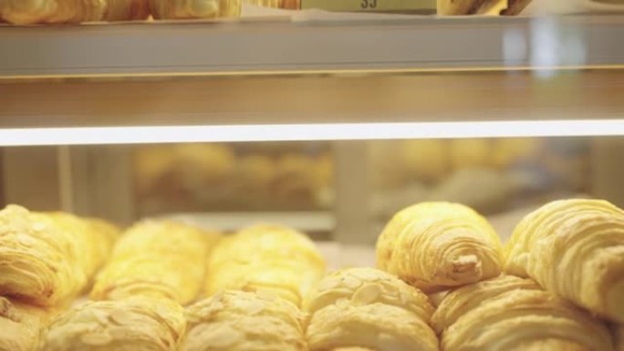 在面包店的陈列柜中展示了新鲜出炉的羊角面包。
