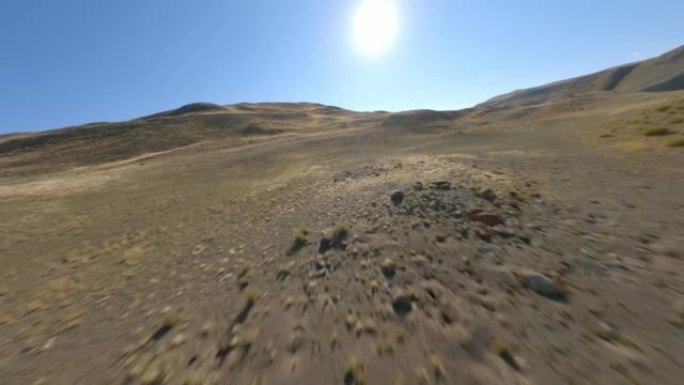 FPV运动无人机拍摄阳光全景丘陵沙漠地形黄色干燥结构阳光蓝天