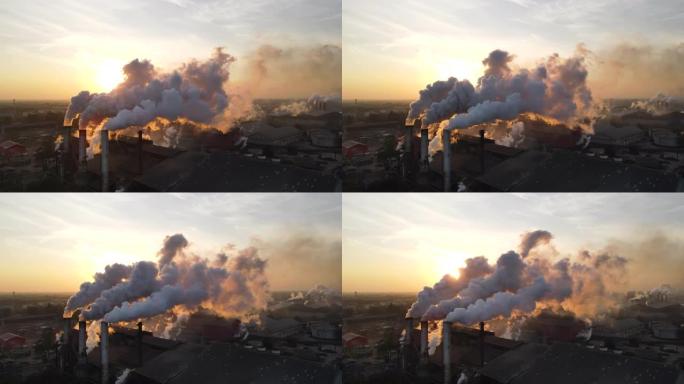 日出时工厂烟囱冒烟的鸟瞰图