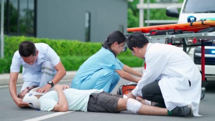 受伤的人躺在路上感到痛苦。救护车来到事故区域，紧急救援队和医生在转移到医院之前进行急救。工作人员为男
