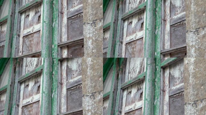 在一所废弃的农村房屋中，用破裂的胶合板盖住了陈旧的窗户