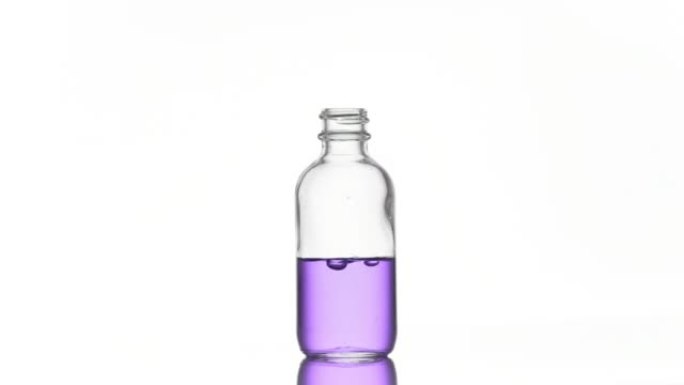烟酰胺正在落入带有紫色液体的医疗瓶中