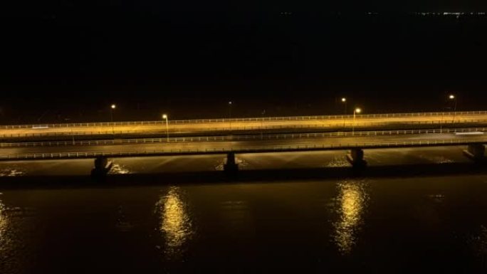 空中无人机在穿越宋卡湖，Tinsulanonda大桥的桥上的交通汽车的昼夜场景。泰国宋卡跨湖大桥沿线