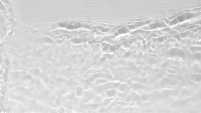 用波浪和光反射近距离观察水的纹理。视频模型的水叠加效果。有机浅灰色水滴阴影苛性效应与光的折射。慢动作