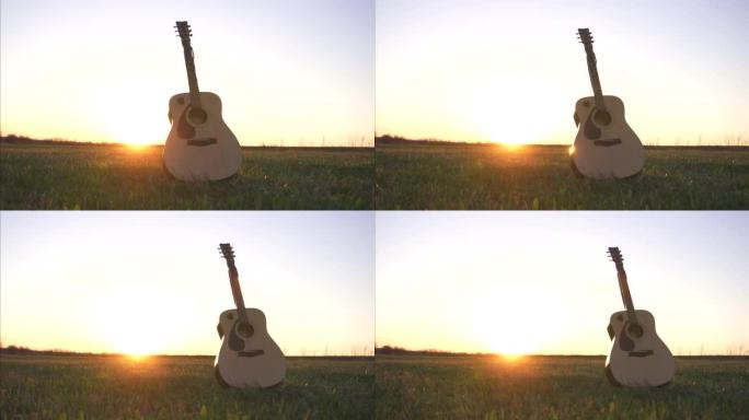 草地上日落时田野中的原声吉他