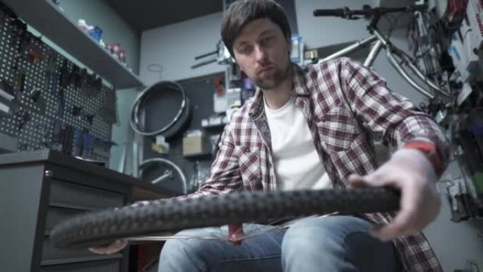 一名自行车机械师更换自行车内胎和轮胎，并在修理厂固定自行车轮。自行车轮胎保养。技术人员正在修理自行车