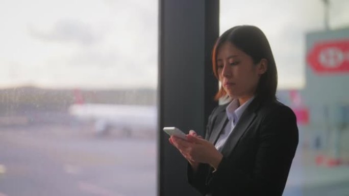 在机场使用智能手机的女商人。商务旅行。