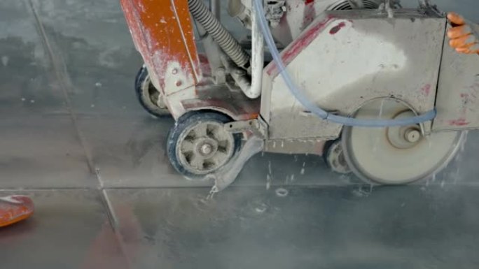 4K，在施工现场的亚洲工程师的监督下，使用锯片将混凝土切割成凹槽的壁锯小型工作机关闭。