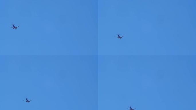 从远处飞行的客机上的地面仰视图。一架小型客机在远处飞过蓝色的万里无云的天空。