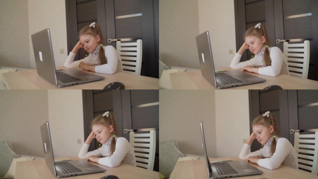 女生坐在家里拿着笔记本电脑。聪明的小女孩在客厅里做作业。她坐在办公桌前，从事自学工作，并使用笔记本电