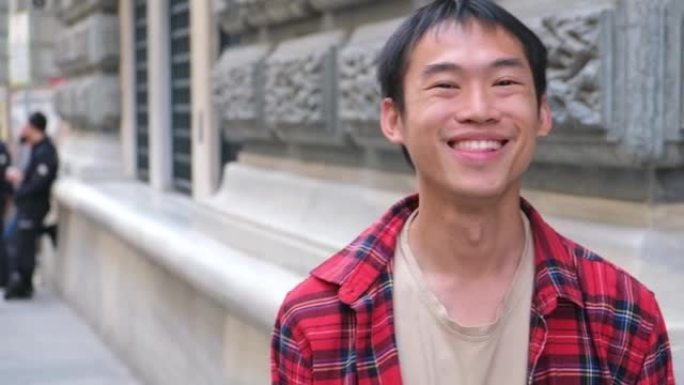 街头学生博客游客中年轻英俊的亚洲男子红衫对镜头微笑的肖像