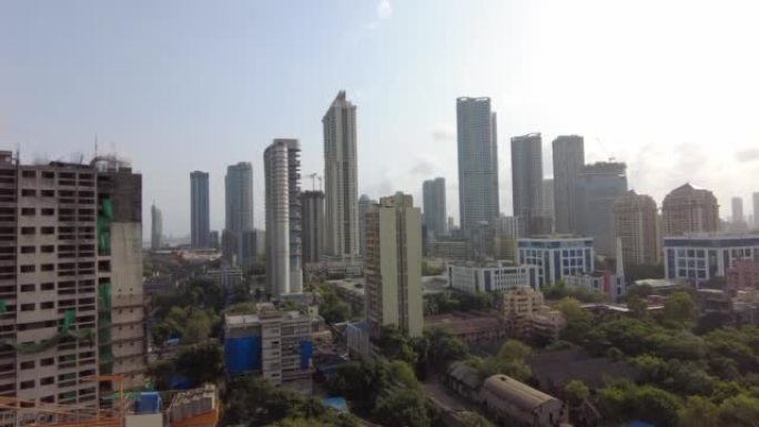 印度孟买市的空中平移镜头。风景秀丽的天际线在戏剧性的天空和阳光下。