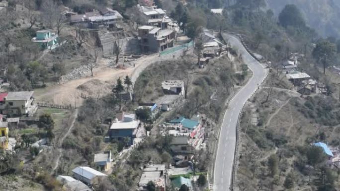 在印度北阿坎德邦奈尼塔尔 (Nainital) 的山区道路上行驶的交通车辆的俯视图，从山顶观看交通车