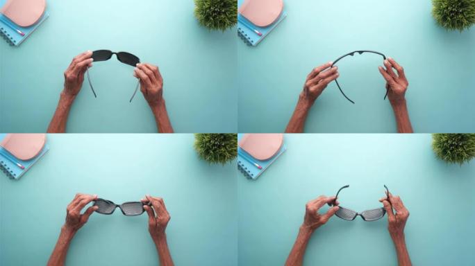 老年女性手持穿孔眼镜训练视力的俯视图