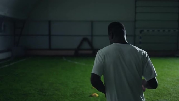 运动年轻黑人在足球场训练，后视图，中等慢动作射击