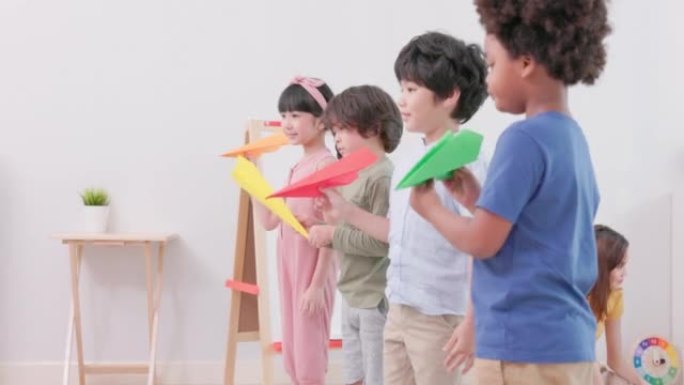 一架纸飞机在亚洲幼儿园折叠起来飞行。在家上学期间在客厅玩耍。在进入幼儿园之前，应该发展孩子的学习能力