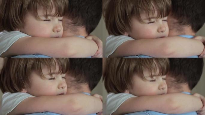 拥抱养父的男孩。幸福的家庭。可爱的小孩儿子拥抱爸爸拥抱享受温柔的时刻。深情的小男孩闭着眼睛拥抱父亲。